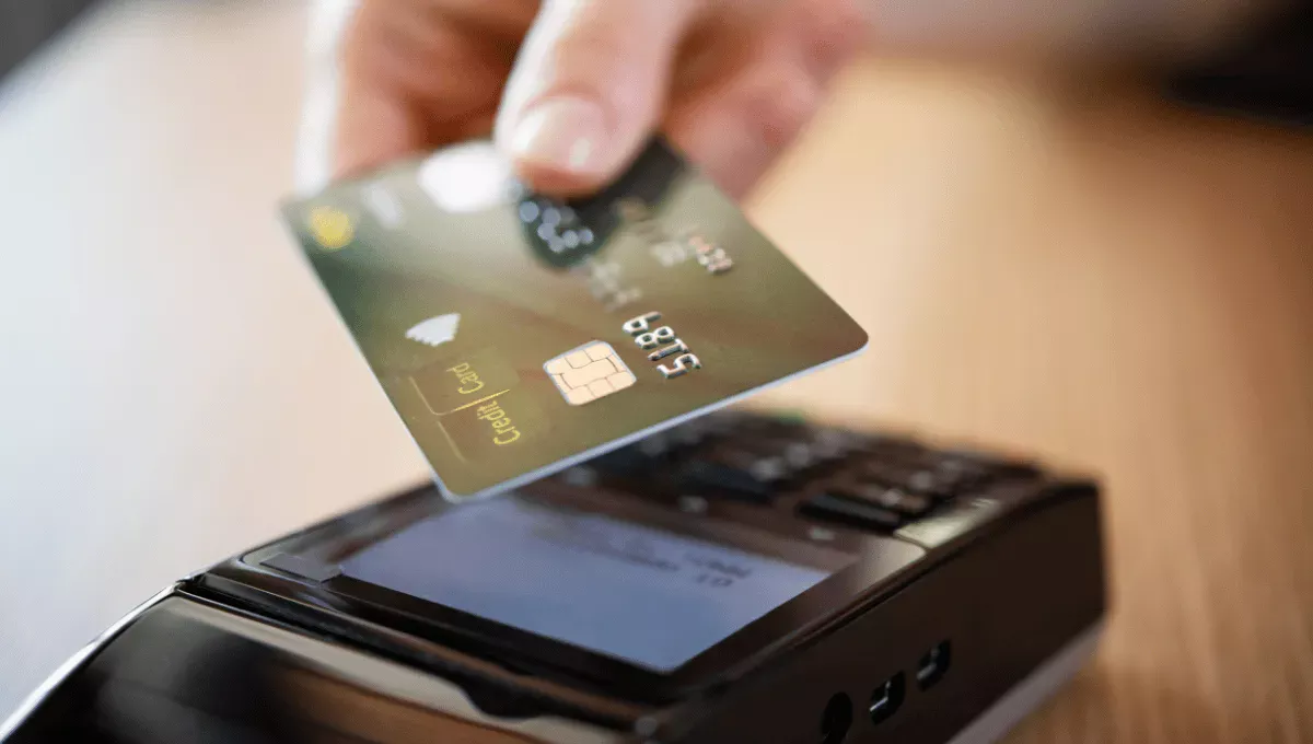クレジットカードを端末にかざして支払いする様子